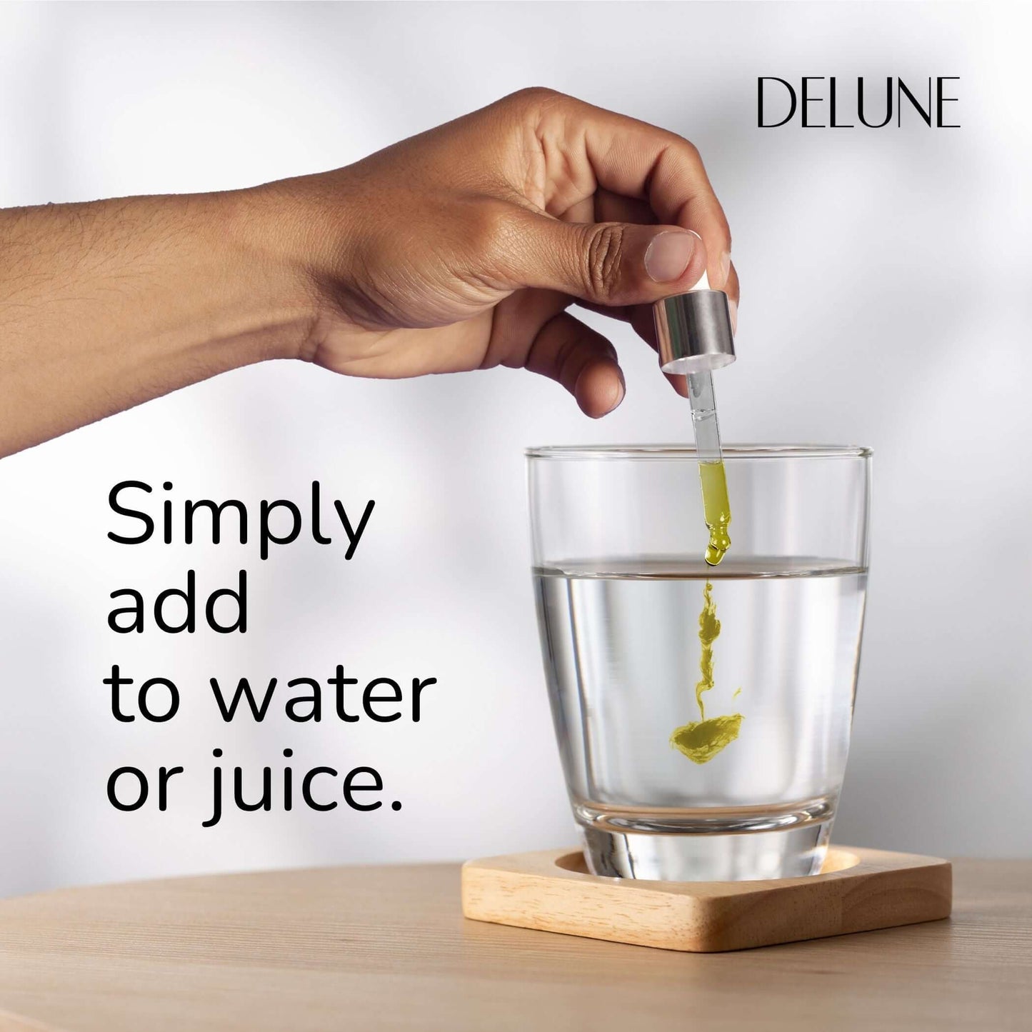 Adding organic lemon balm tincture to a glass of water, showcasing ease of use for stress relief and calming benefits.