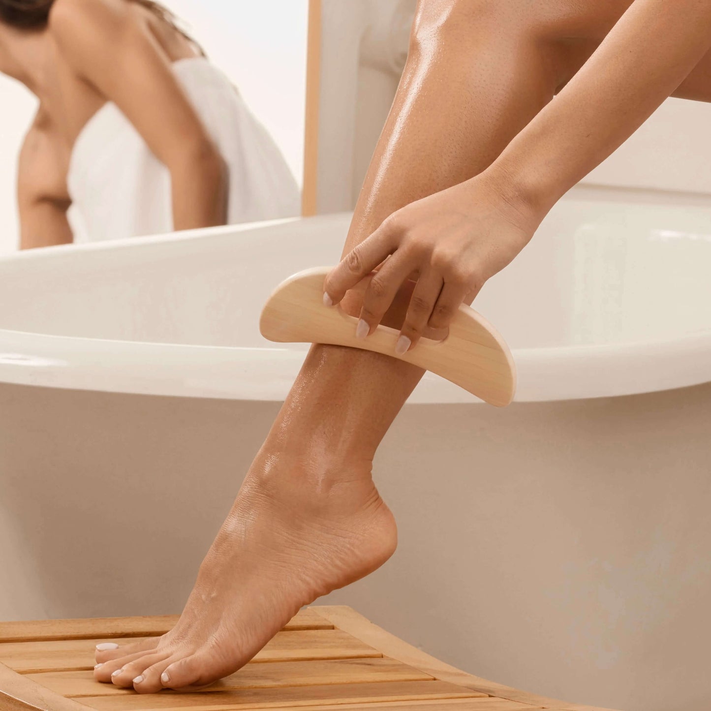 Person using Delune Wooden Body Massager on leg for muscle relaxation and tension relief in a bathroom setting.