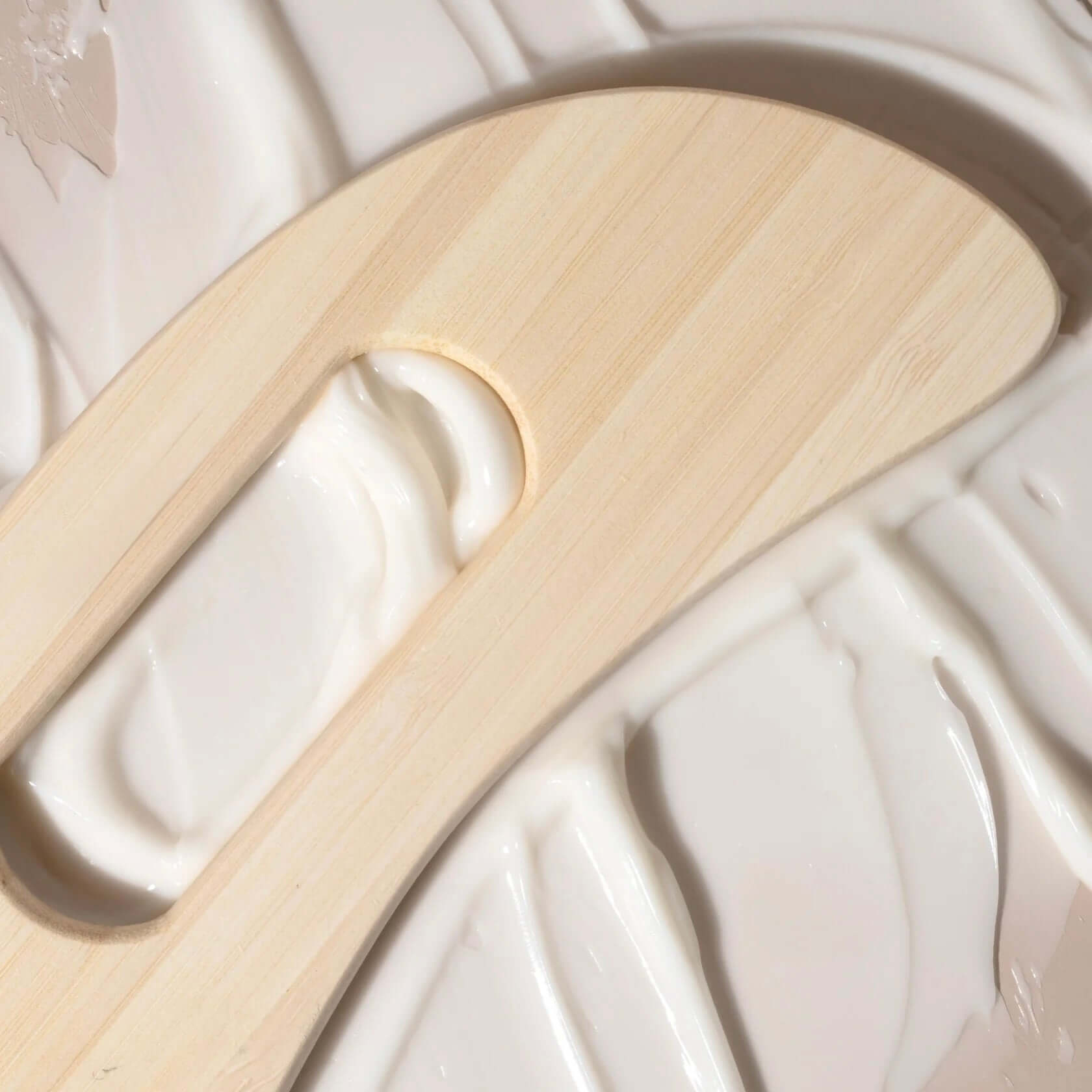 Elegant Delune Wooden Body Massager on smooth lotion surface, ideal for reducing muscle tension and promoting relaxation.