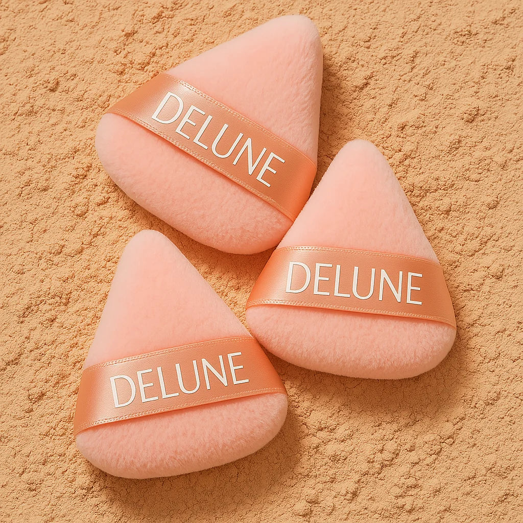 Set of three soft-touch tear-shaped powder puffs with velvet texture for precise makeup application on a textured background.