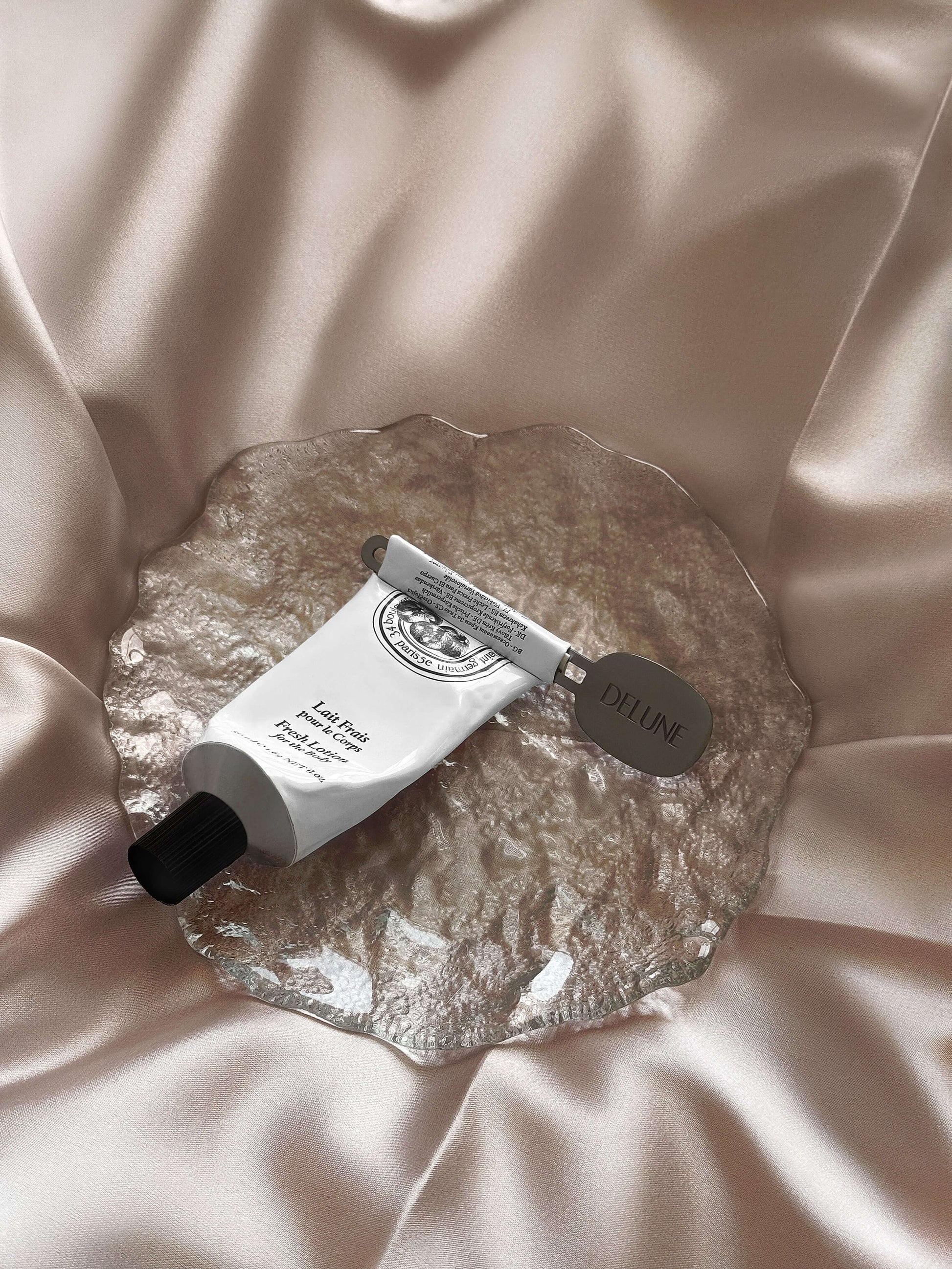 Tube Key Squeezer on elegant surface, squeezing toothpaste tube to reduce waste, sustainable metal alloy design perfect for travel.