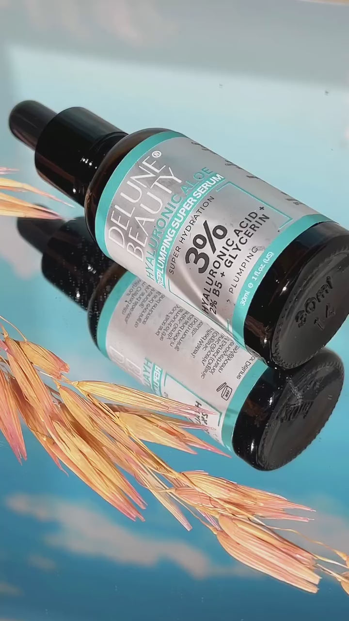 Delune's 3% Hyaluronic Aloe Face Serum bottle on reflective surface with wheat in foreground.