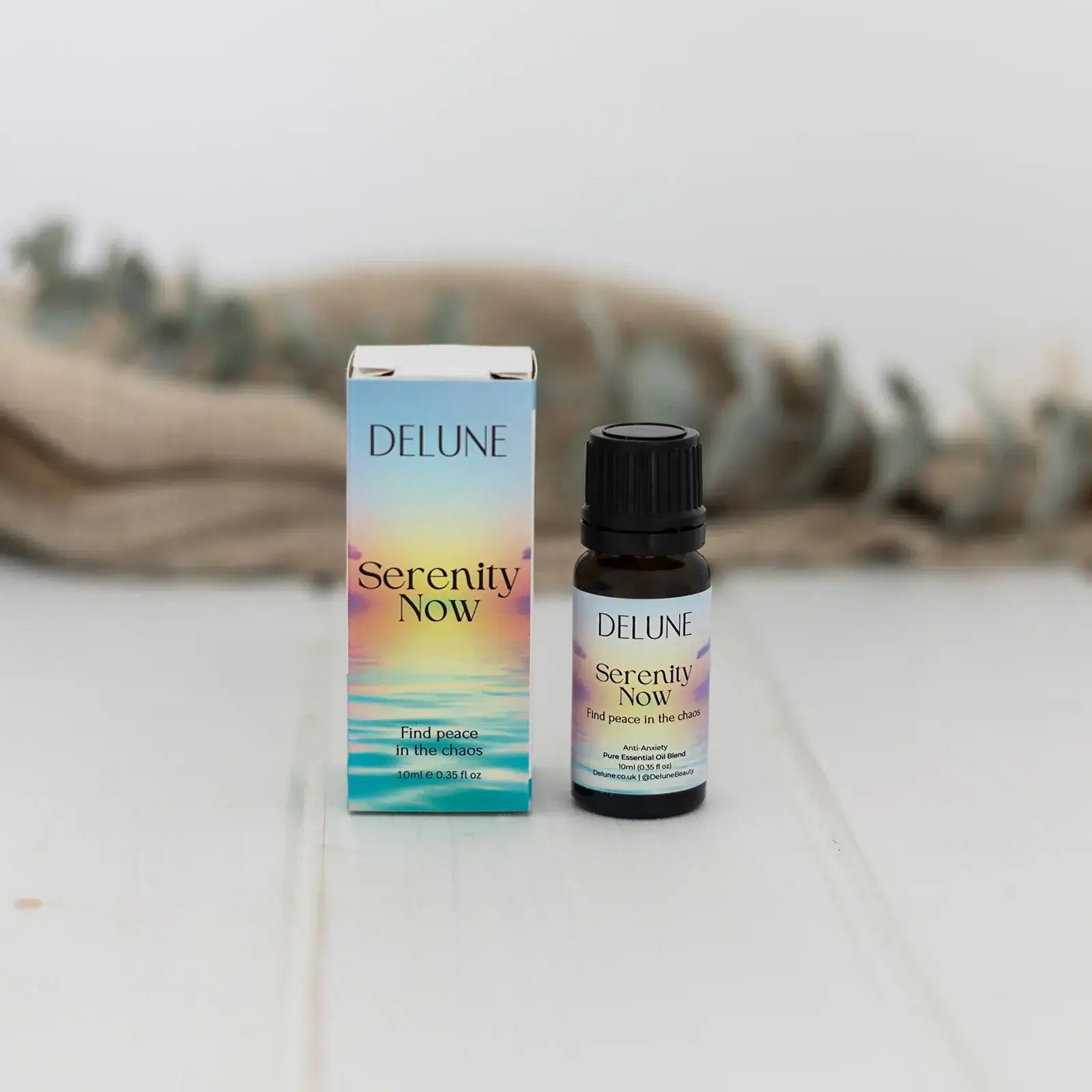 Serenity Now essential oil blend bottle and box promoting anti-anxiety and relaxation benefits with floral and grounding scents.