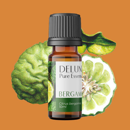 Bergamot Pure Essential Oil bottle with fresh bergamot fruit background on orange surface.