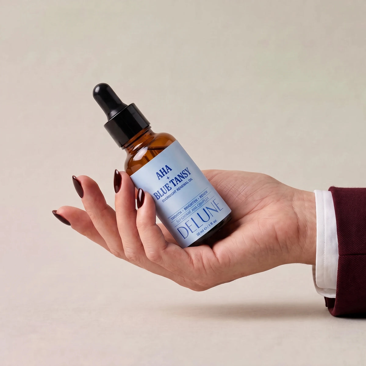 Face oil UAE – Delune Dubai AHA + Blue Tansy Overnight Renewal Oil held in an open hand
