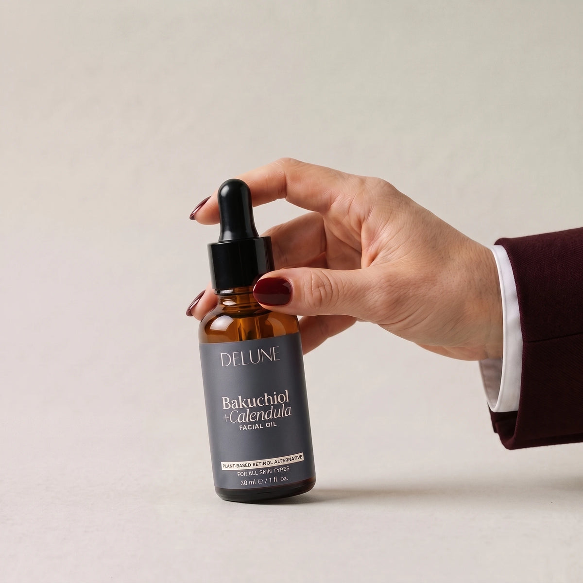 Face oil UAE – Hand picking up Delune Dubai Bakuchiol + Calendula Facial Oil