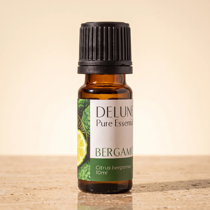 Delune Bergamot Pure Essential Oil, 10ml amber glass bottle on warm travertine stone