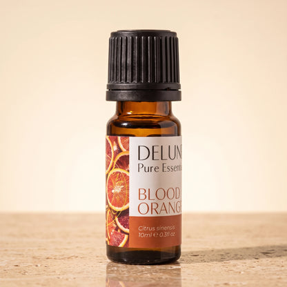 Delune Blood Orange Pure Essential Oil, 10ml amber glass bottle on warm travertine stone