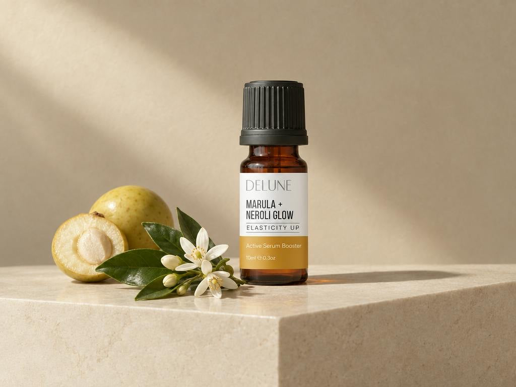 Marula + Neroli Glow Active Serum Booster on travertine with marula fruit and orange blossom
