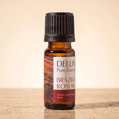 Delune Brazilian Rosewood Pure Essential Oil, 10ml amber glass bottle on warm travertine stone