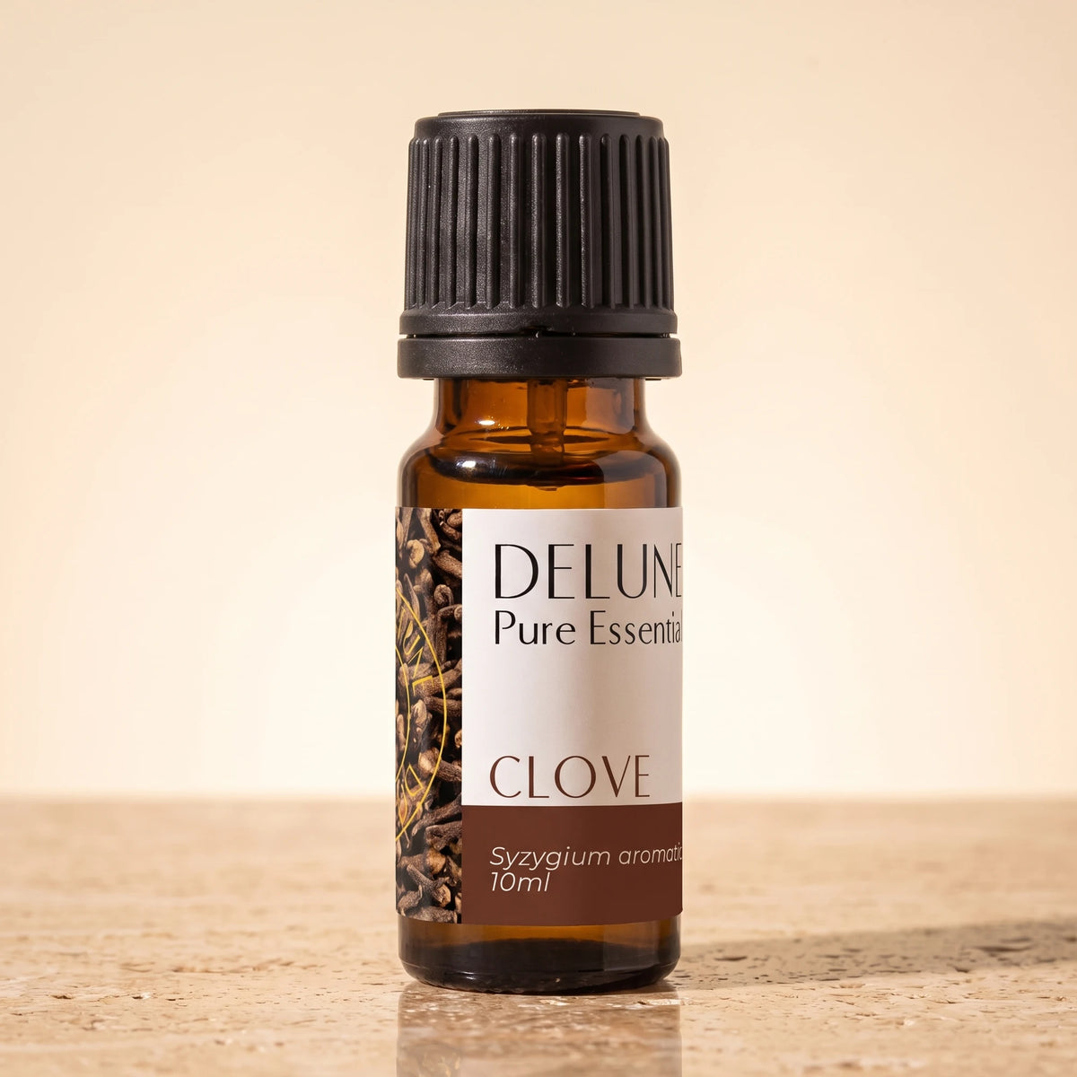 Clove essential oil UAE – Delune Dubai Clove Pure Essential Oil, 10ml amber glass bottle on warm travertine stone