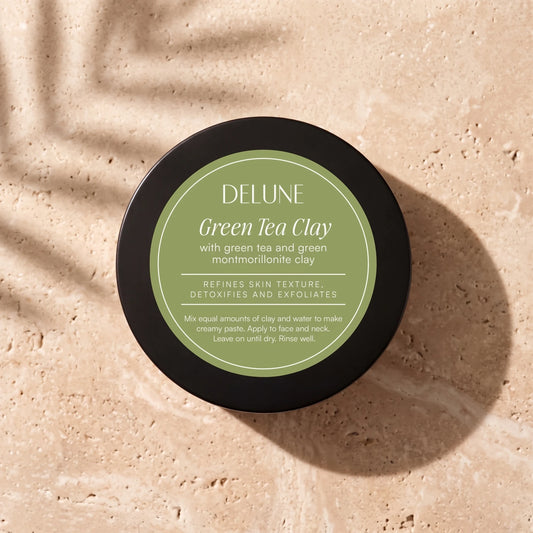 Clay face mask UAE – Delune Dubai Green Tea Clay Mask jar from above on warm travertine in soft window light