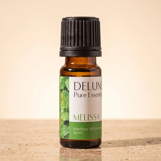 Delune Melissa Pure Essential Oil, 10ml amber glass bottle on warm travertine stone