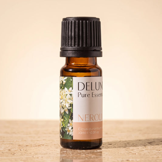 Delune Neroli Pure Essential Oil, 10ml amber glass bottle on warm travertine stone