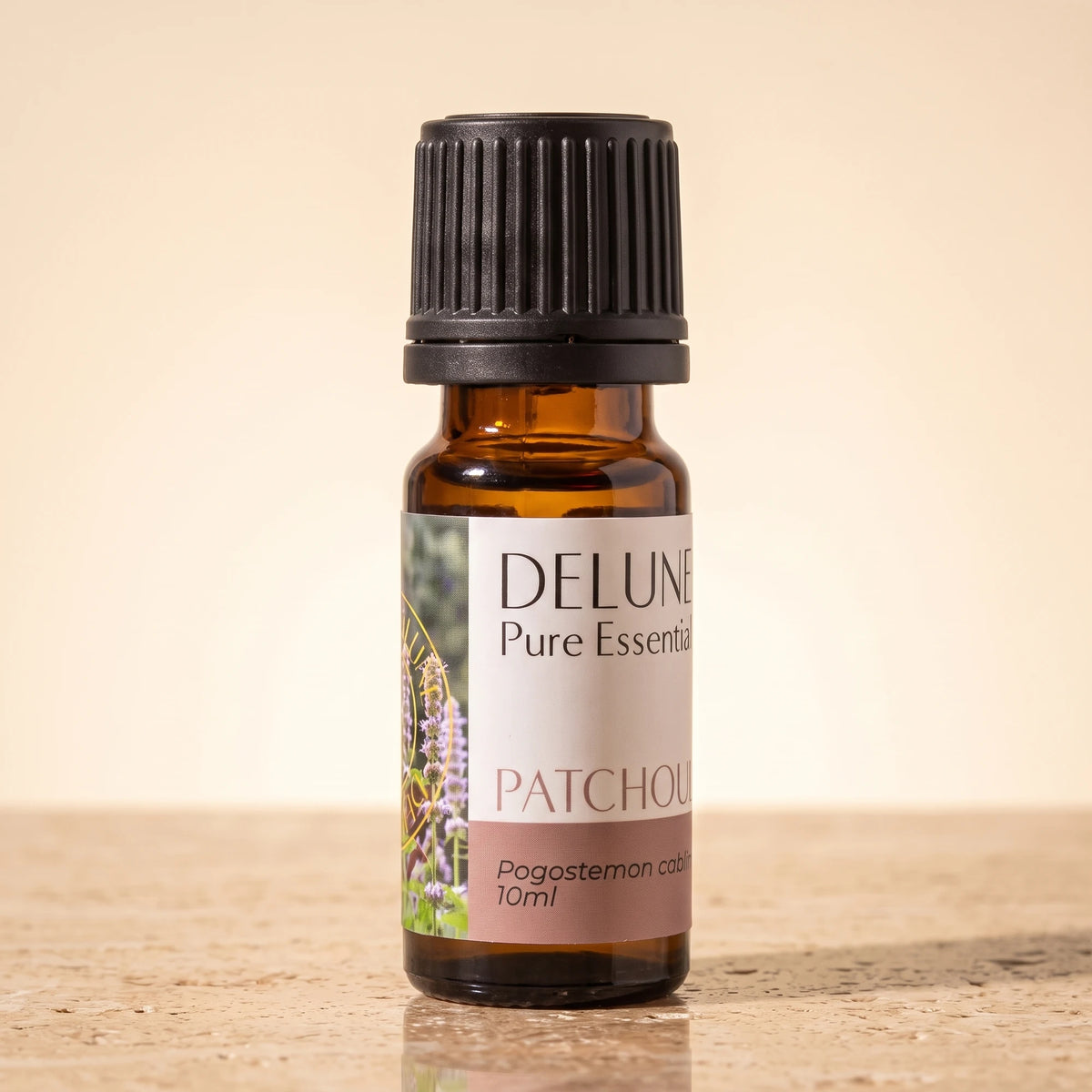 Patchouli essential oil UAE – Delune Dubai Patchouli Pure Essential Oil, 10ml amber glass bottle on warm travertine stone
