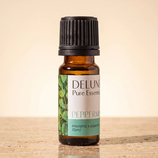 Delune Peppermint Pure Essential Oil, 10ml amber glass bottle on warm travertine stone