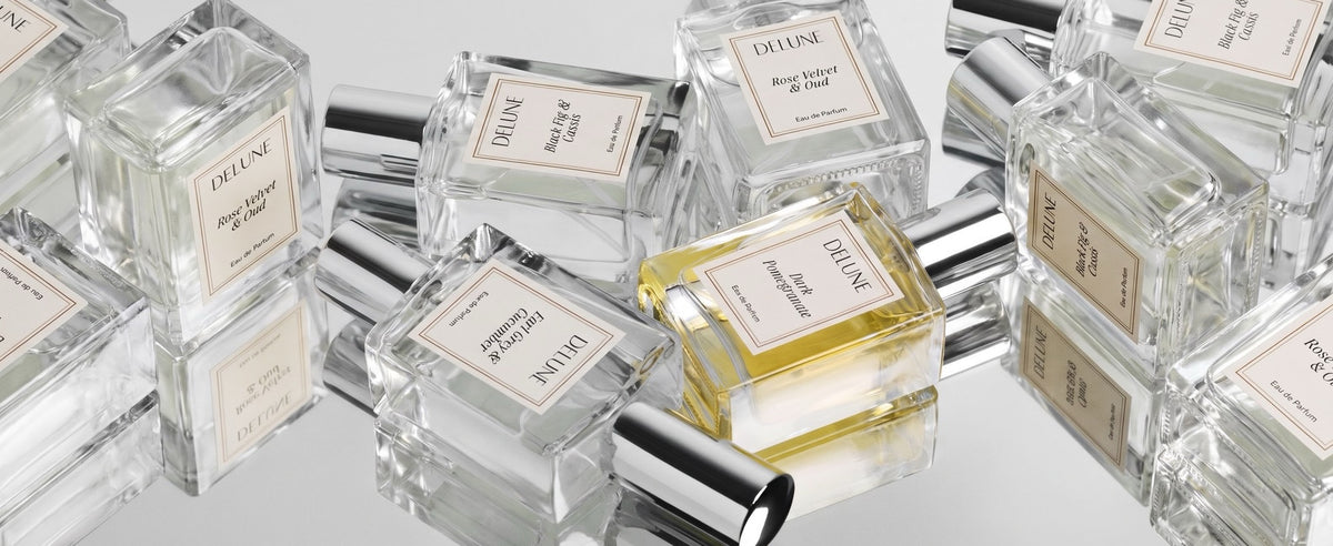 Delune eau de parfum bottles laid in a close spread: Rose Velvet & Oud, Black Fig & Cassis, Earl Grey & Cucumber and Dark Pomegranate