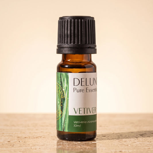 Delune Vetiver Pure Essential Oil, 10ml amber glass bottle on warm travertine stone