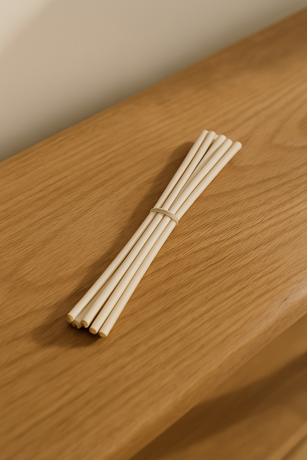 Bundle of 6 biodegradable rattan diffuser reeds on a wooden surface. Perfect for eco-friendly reed diffuser replacement.